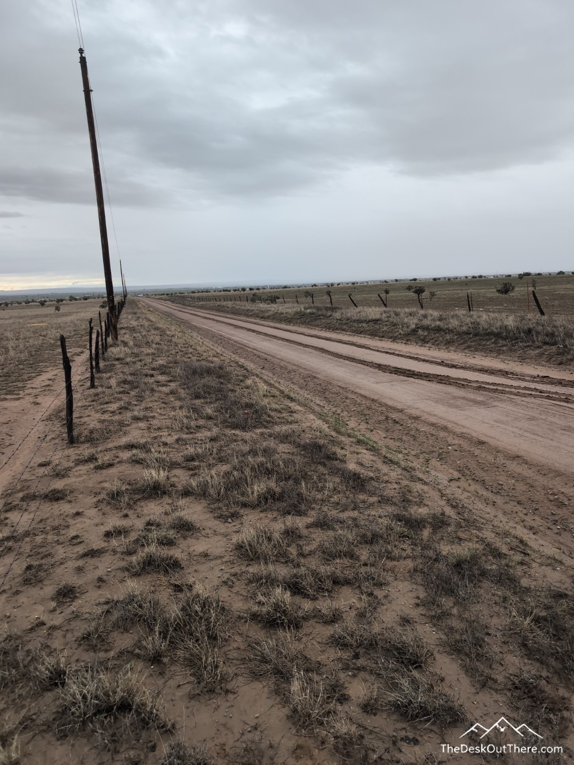 Muddy rural road under grey skies.